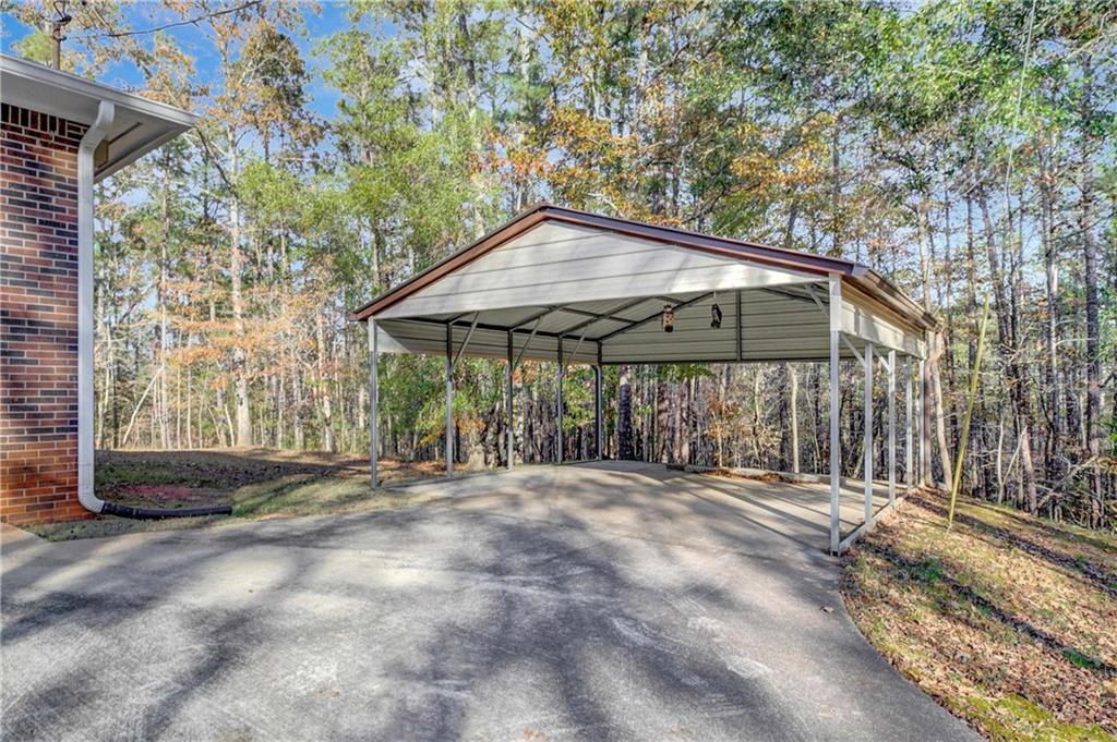10185 Henry Mill Road Chattahoochee Hills, GA 30213 - Photo 36 of 41 a backyard of a house with table and chairs under an umbrella