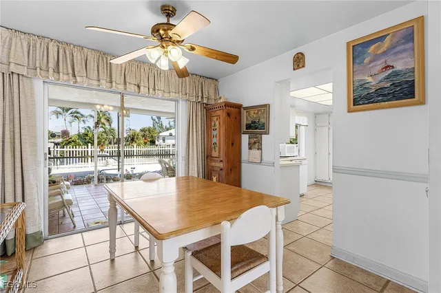 a kitchen with stainless steel appliances kitchen island granite countertop a refrigerator a stove a microwave oven with a dining table and chairs