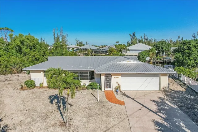 a view of a house with backyard and sitting area