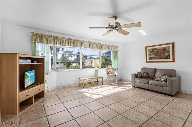 a living room with furniture a flat screen tv and a floor to ceiling window