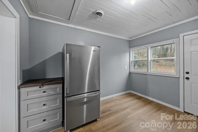 a view of a refrigerator in kitchen and a window