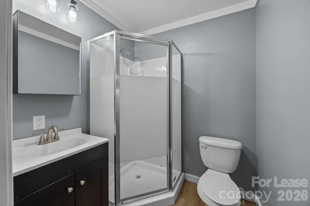 a bathroom with a toilet sink vanity and mirror