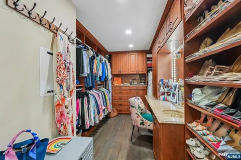 a view of walk in closet with clothes and shoes
