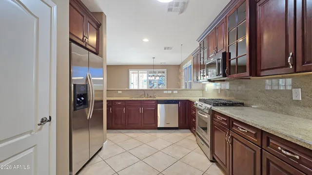 a kitchen with stainless steel appliances granite countertop a refrigerator and a sink