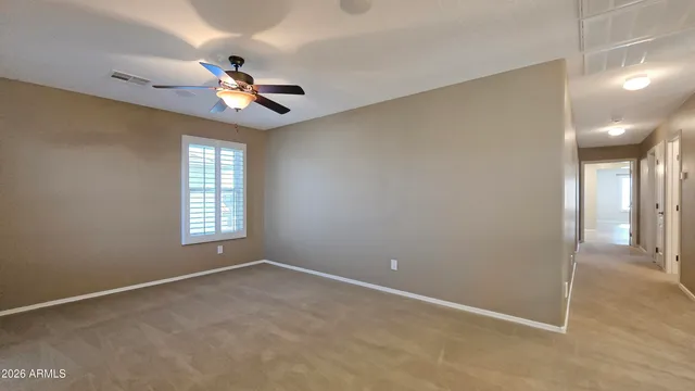 an empty room with windows and fan