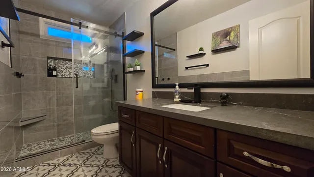 a bathroom with a sink a toilet and shower