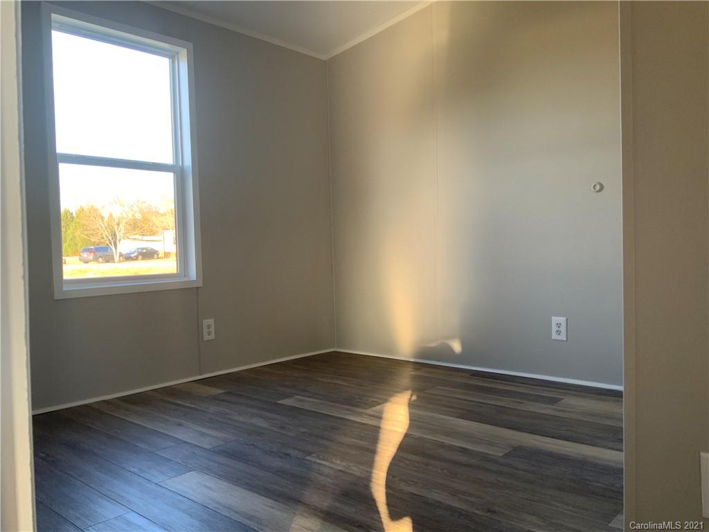 115 Riting Road, Unit 58 Salisbury, NC 28147 - Photo 12 of 23 a view of an empty room with wooden floor and a window