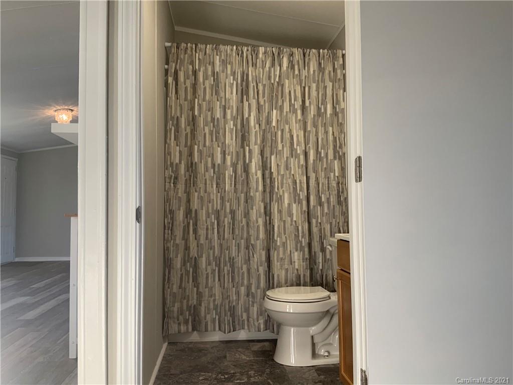 115 Riting Road, Unit 58 Salisbury, NC 28147 - Photo 10 of 23 a white toilet sitting next to a shower curtain