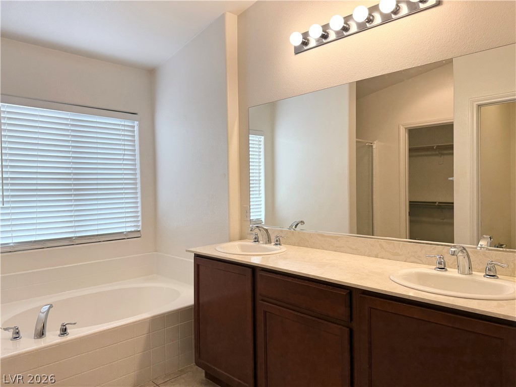 8231 Buffalo Ranch Avenue Las Vegas, NV 89147 - Photo 14 of 22 A well-appointed primary bathroom featuring a spacious built-in tub and a dual vanity with ample counter space.