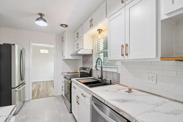 a kitchen with a sink stove and refrigerator