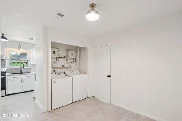 a kitchen with white cabinets and stove