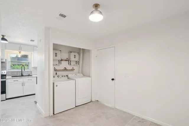 a kitchen with white cabinets and stove