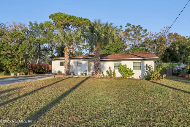 a front view of a house with a yard and trees