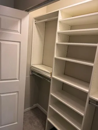 a view of walk in closet with empty racks