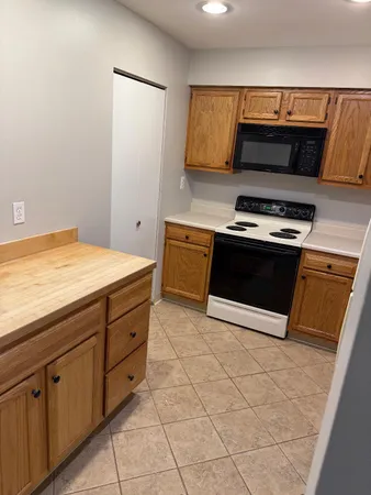 a kitchen with granite countertop a stove a sink and a microwave