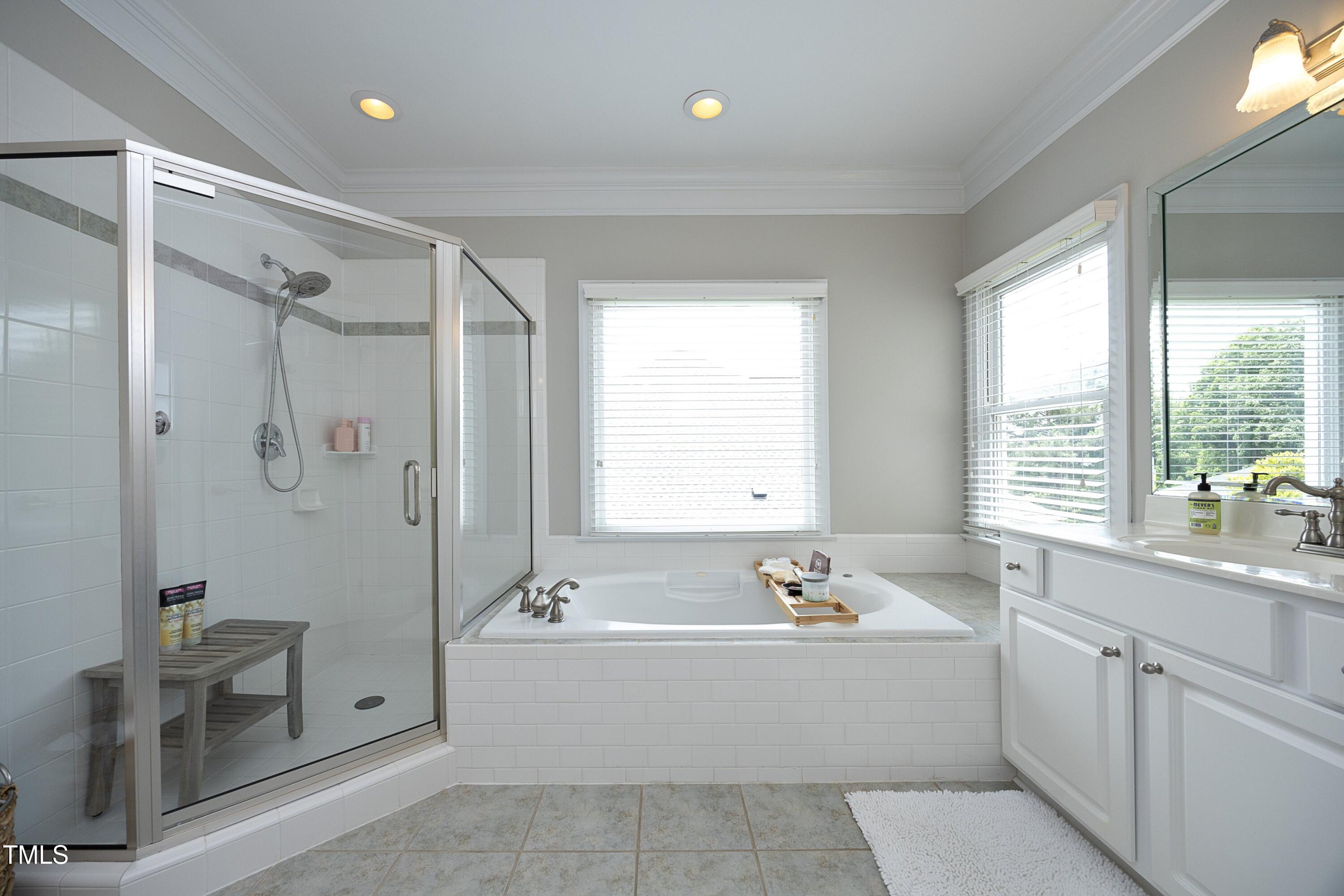 2800 Charleston Oaks Drive Raleigh, NC 27614 - Photo 34 of 53 a bathroom with a tub a sink a window and a shower
