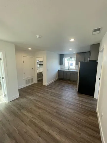 a view of empty room with wooden floor