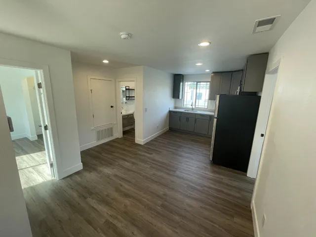 a view of a big room with wooden floor and windows