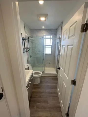 a bathroom with a sink a toilet and shower