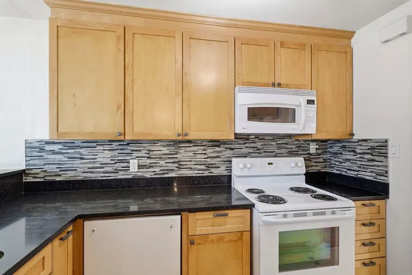 a kitchen with granite countertop cabinets stainless steel appliances and a sink