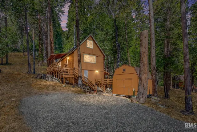 a view of a house with backyard and trees