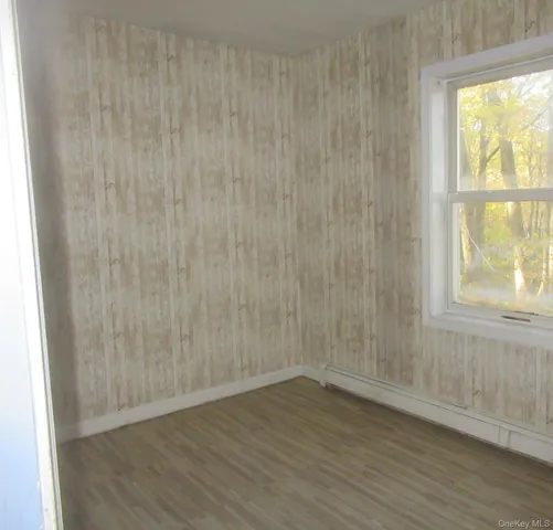 a view of a small space with wooden floor and a window