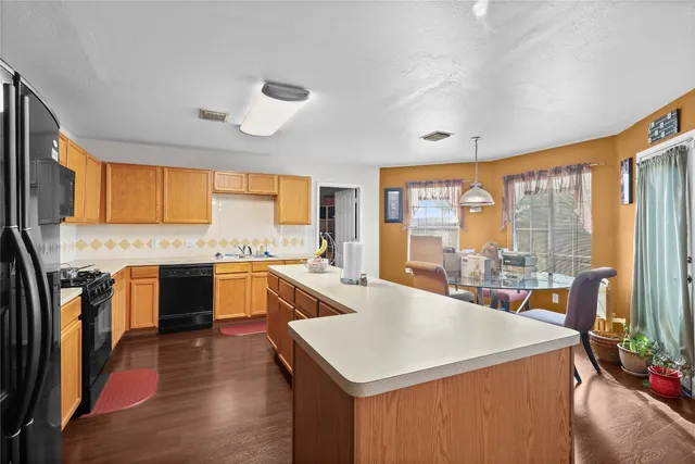 a large kitchen with a stove a sink a refrigerator and cabinets