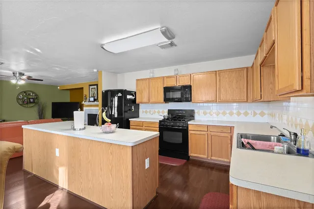 a kitchen with stainless steel appliances granite countertop a sink stove refrigerator and cabinets