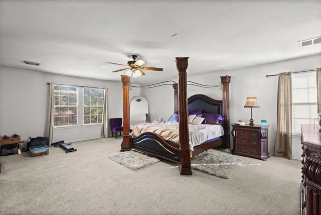 a bedroom with a bed and a flat tv screen on wall