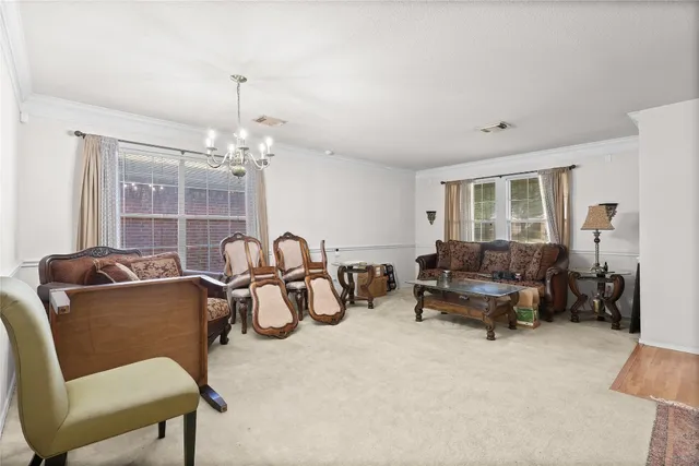 a living room with furniture a chandelier and a window