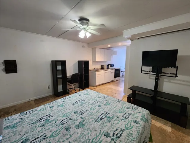 a bedroom with a bed and a flat tv screen on dresser