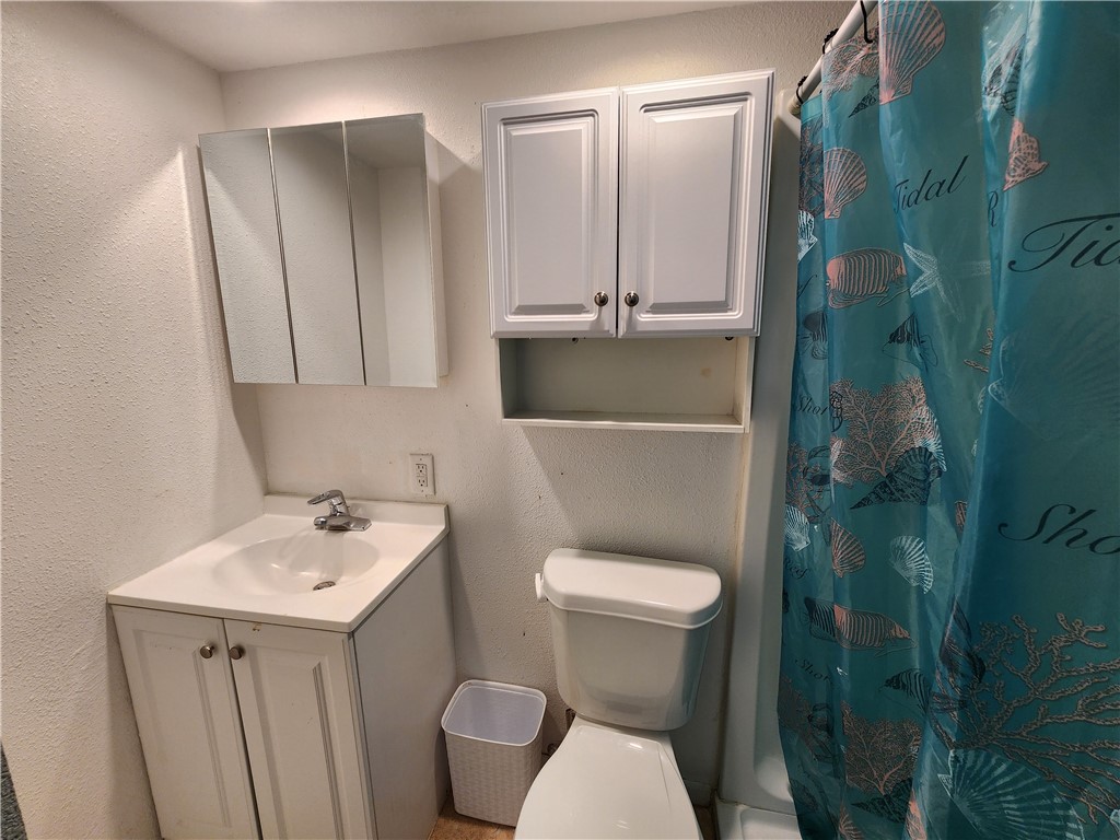 14300 South Padre Island Drive, Unit 16 Corpus Christi, TX 78418 - Photo 8 of 20 a bathroom with a toilet a sink and mirror