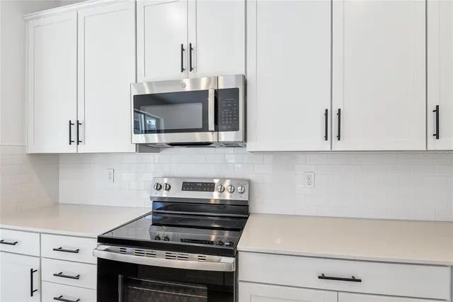 a kitchen with appliances a sink and cabinets