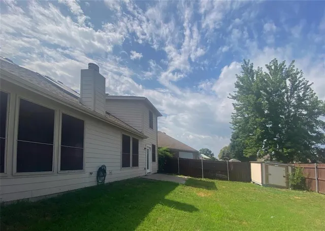 a view of a backyard with a large tree