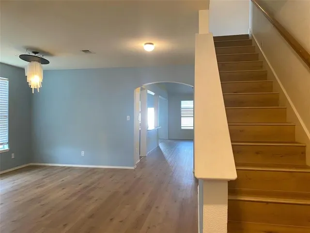 a view of a hallway with wooden floor and staircase
