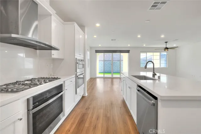 a kitchen with white cabinets sink and stainless steel appliances