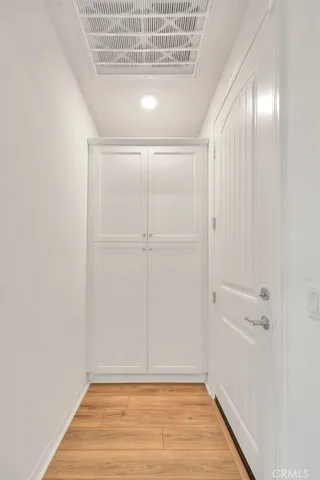 a view of hallway with a large window and hardwood floor