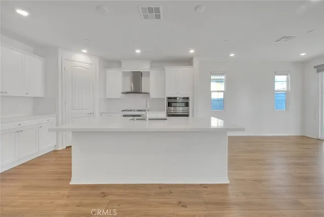 a view of kitchen with stainless steel appliances granite countertop cabinets and wooden floor