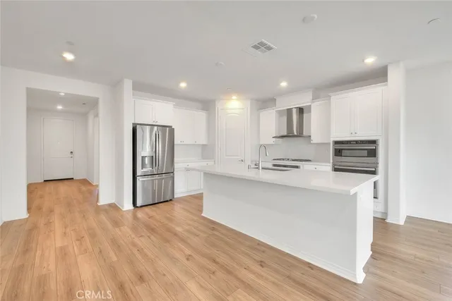 a kitchen with stainless steel appliances a refrigerator and a stove top oven