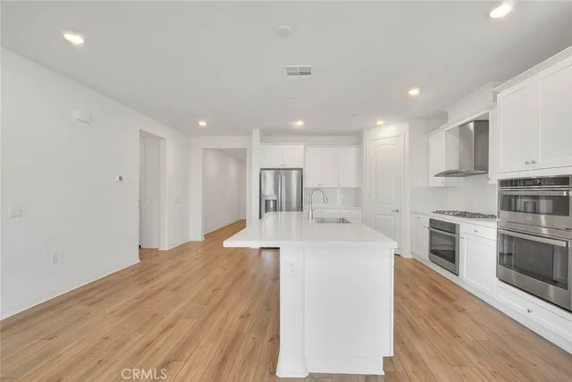 a large kitchen with stainless steel appliances granite countertop a sink and cabinets