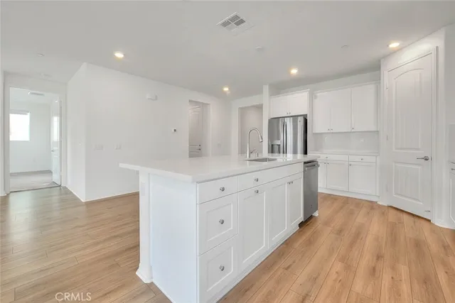 a kitchen with white cabinets stainless steel appliances and sink
