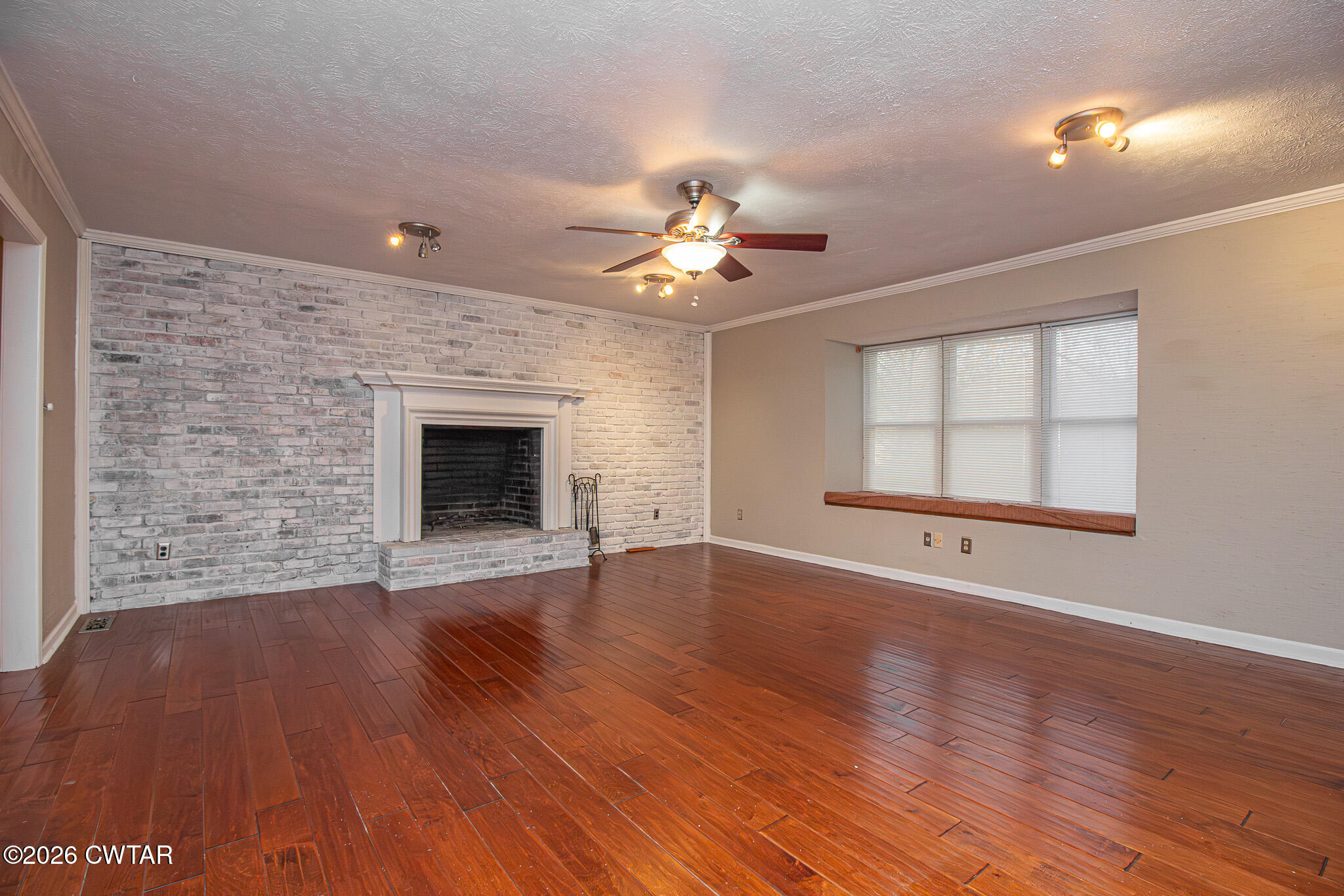 231 Tuckahoe Road Jackson, TN 38305 - Photo 6 of 39 a view of an empty room with wooden floor fireplace and a window