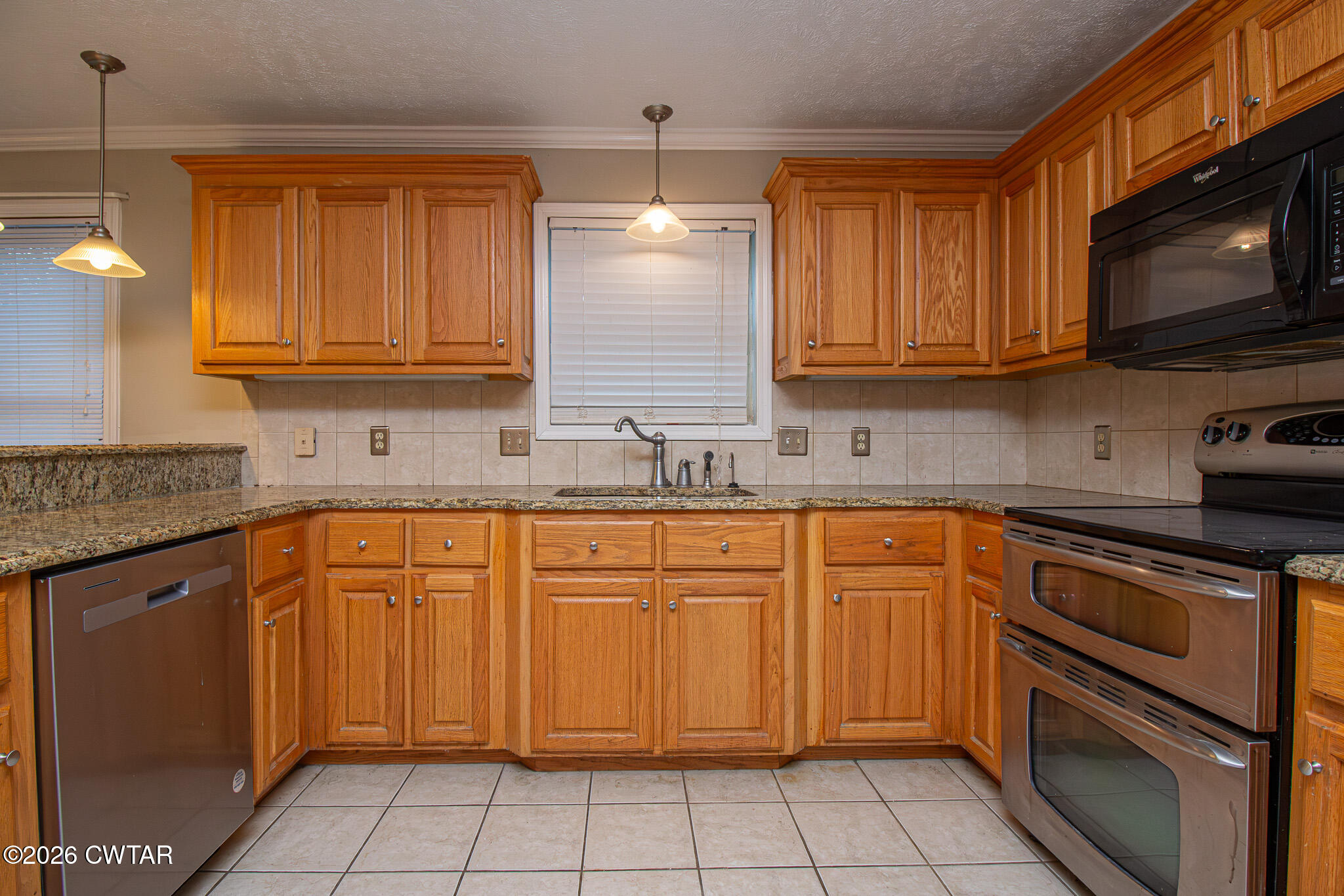 231 Tuckahoe Road Jackson, TN 38305 - Photo 10 of 39 a kitchen with stainless steel appliances granite countertop a sink stove and microwave