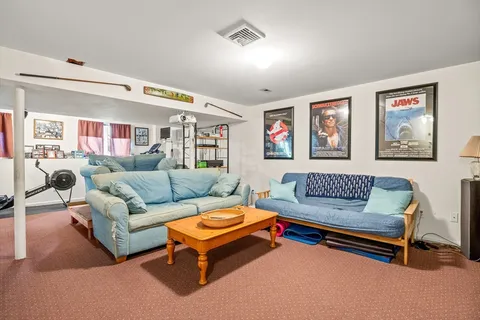 a living room with furniture floor to ceiling window and wooden floor