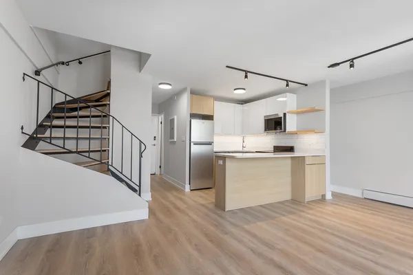 a view of kitchen with stainless steel appliances cabinets and wooden floor