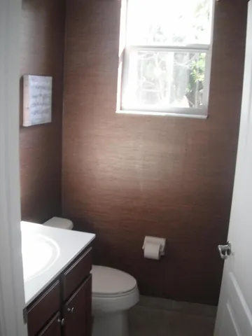 a bathroom with a toilet a sink and a window