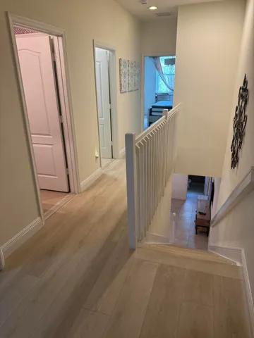 a view of a hallway with staircase and door