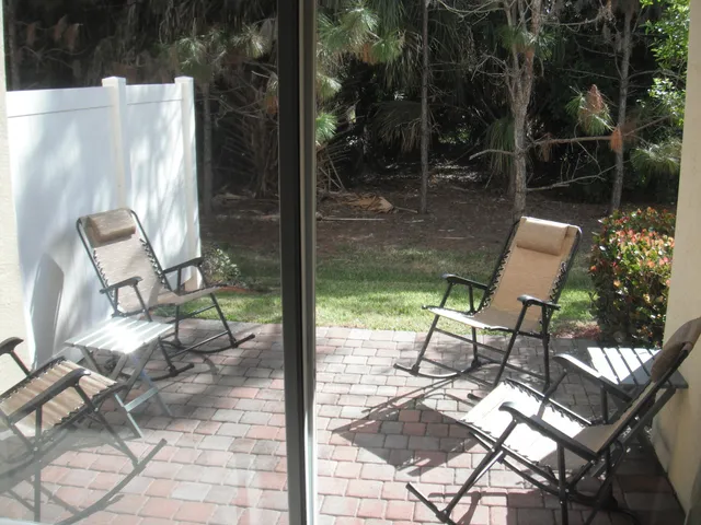 a view of a yard with chairs and wooden fence