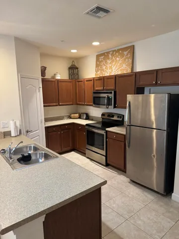 a kitchen with kitchen island a counter top space a sink a stove and refrigerator