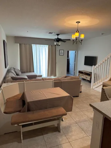 a living room with furniture a chandelier and a flat screen tv